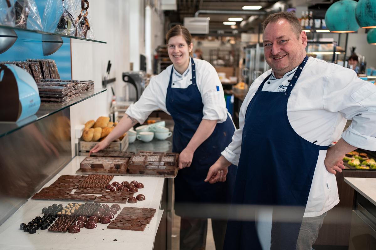 Det er chefkonditor Allan Andersen og bager og konditor Maria Seremet, der i øjeblikket står for chokoladeproduktionen. Her er de i gang med at lave fyldte chokolader med lakrids og kugler med karamelfyld. De sprayfarver selv deres forme med kakaosmør, og der går sjældent noget af produktionen til spilde, for der er styr på tempereringen. 