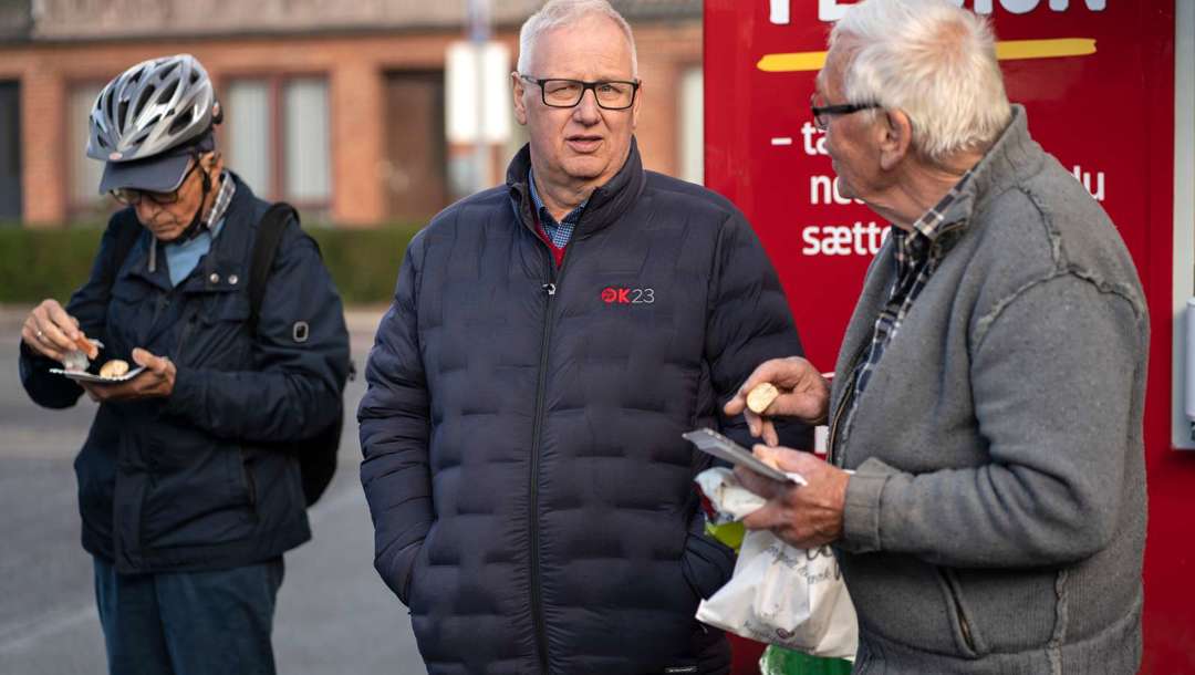 Ole Wehlast taler med handlende fra Grenå, der har fået en pølse og et stykke kage med.