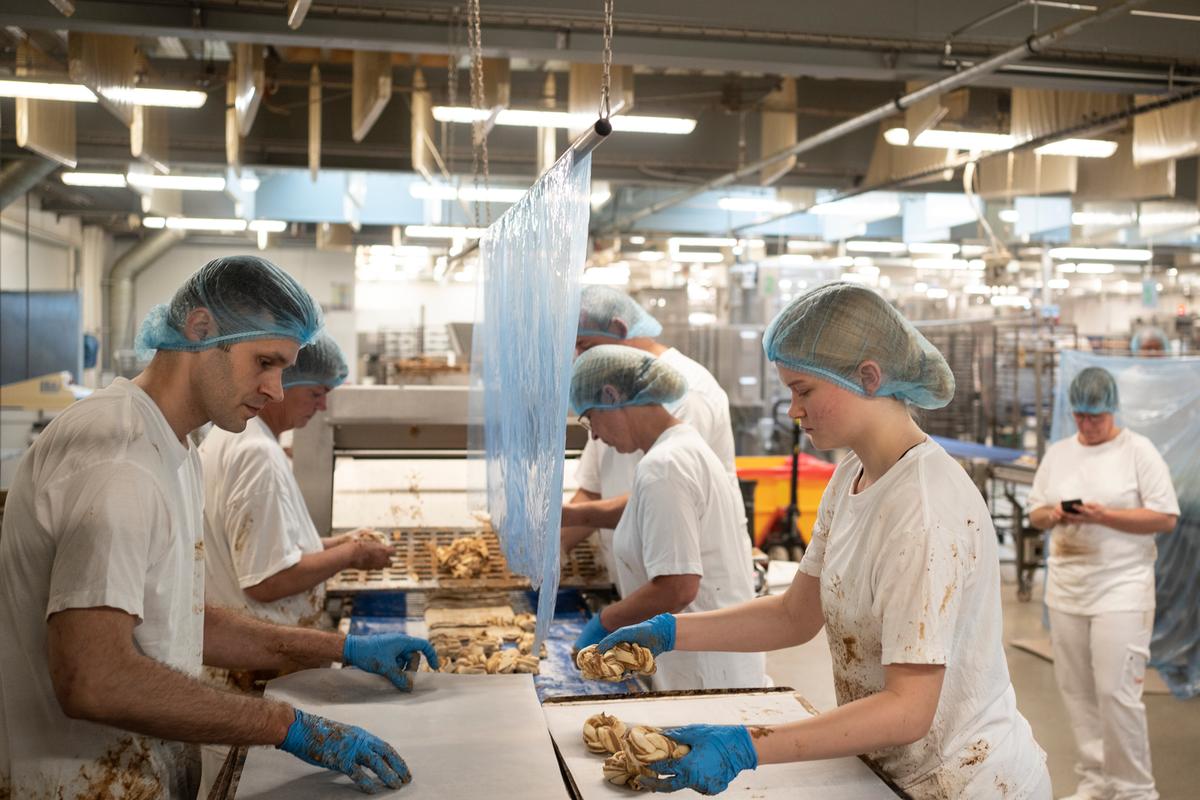 Med en teknik der er umulig at afkode med det blotte øje, folder fem medarbejderne lynhurtigt dejen, så kanelsnurrens udseende lever op til kagens navn. 