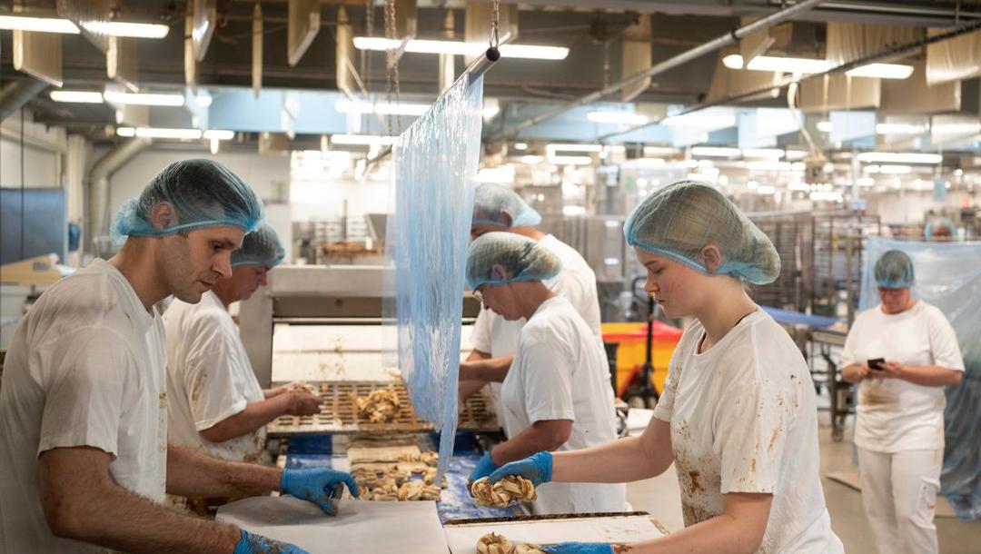 Med en teknik der er umulig at afkode med det blotte øje, folder fem medarbejderne lynhurtigt dejen, så kanelsnurrens udseende lever op til kagens navn. 