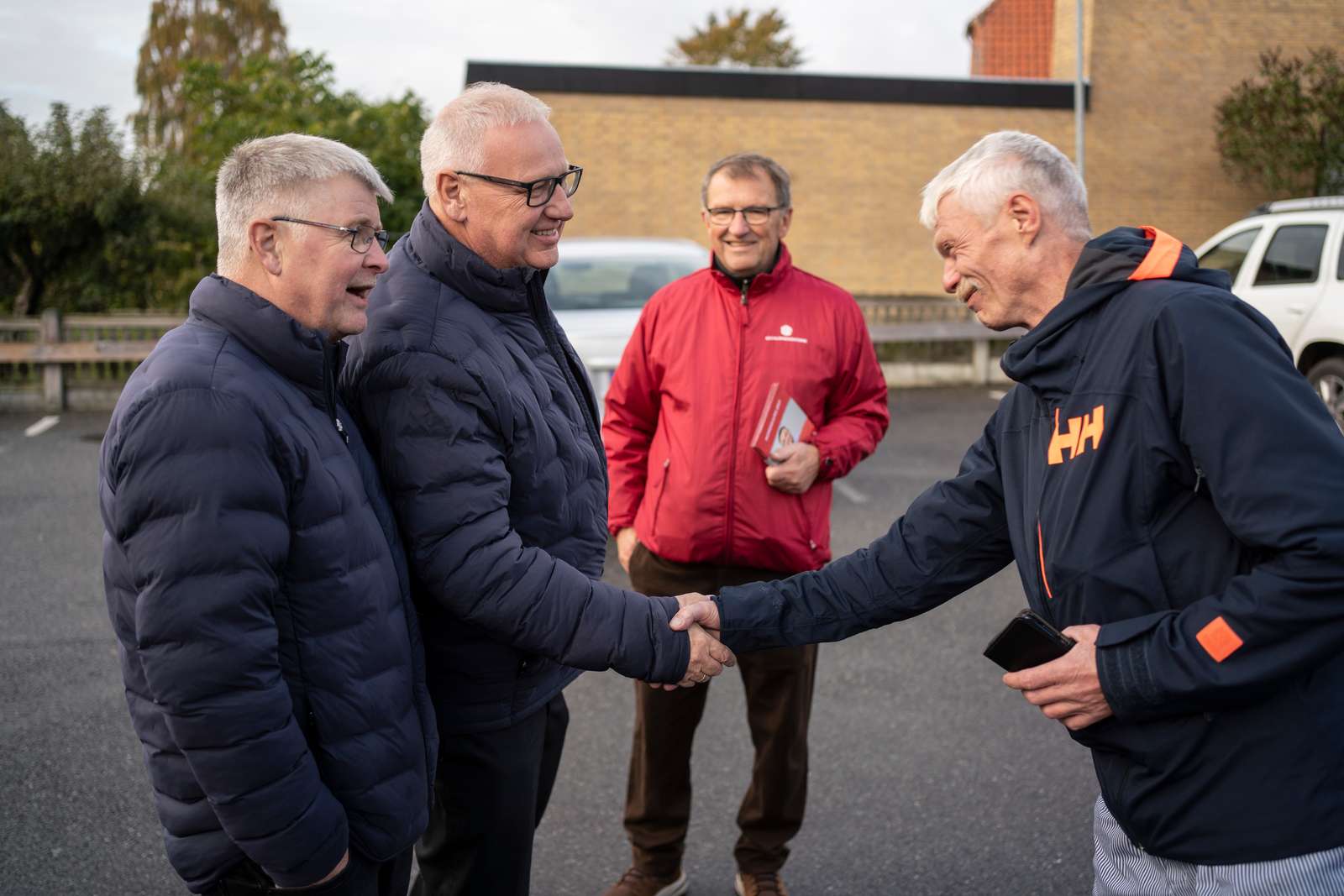 Slagteriarbejder Lars Søndergaard hilser på forbundsformand Ole Wehlast, der er i selskab med afdelingsformand Flemming Hansen.