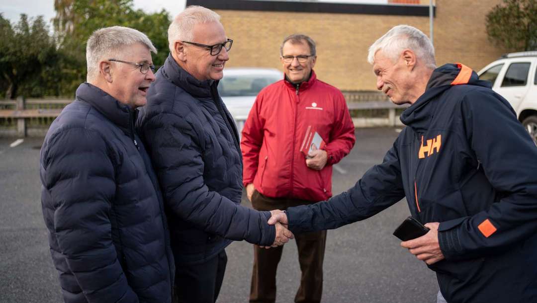 Slagteriarbejder Lars Søndergaard hilser på forbundsformand Ole Wehlast, der er i selskab med afdelingsformand Flemming Hansen.