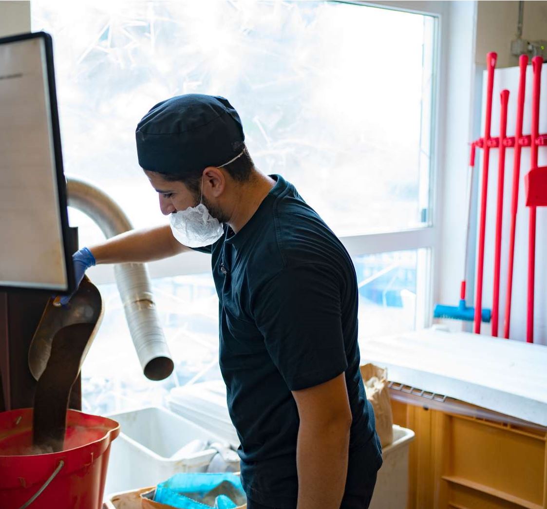 30-årige Yilmaz Yildirin vejer lakridspulveret af til det batch lakrids på 100 kilo, som han er i gang med at producere. Han bruger både fint, sprøjte-tørret lakridsekstrakt og en granuleret version. I dag koger han lakrids med chilipuré fra Gartneri Toftegaard i Køge. 
