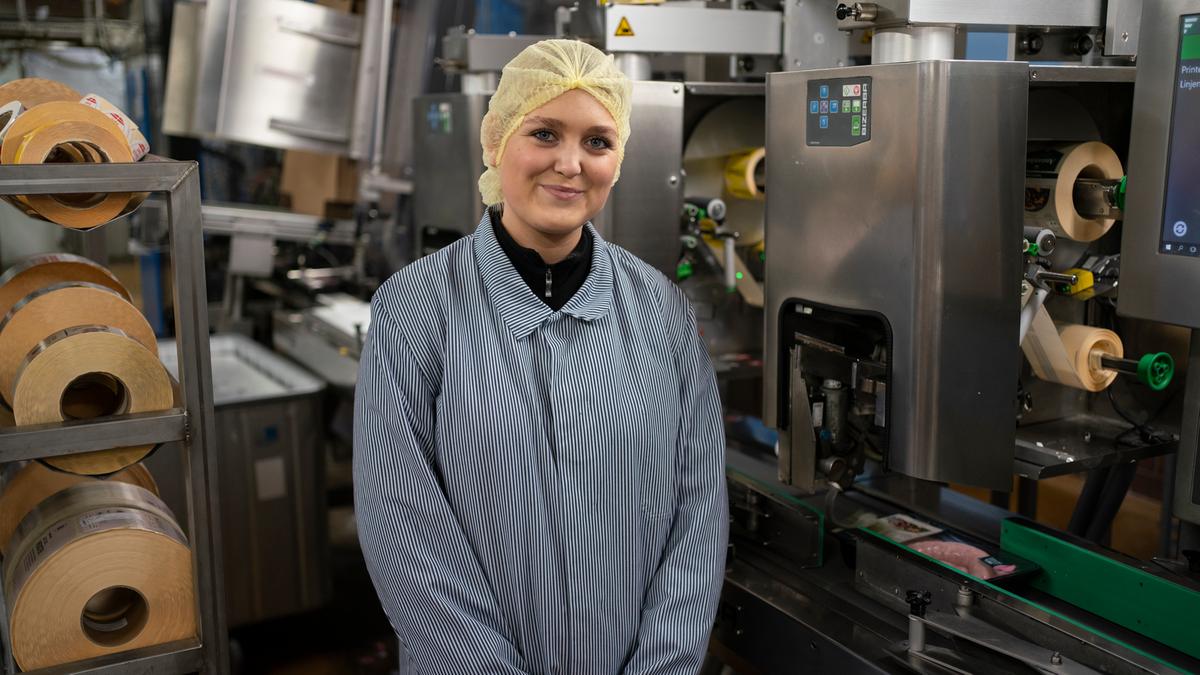 Det gule hårbånd vidner om, at Djuna Veje er ny i etikette-afdelingen, hvor hun skal lære at betjene maskinerne. 