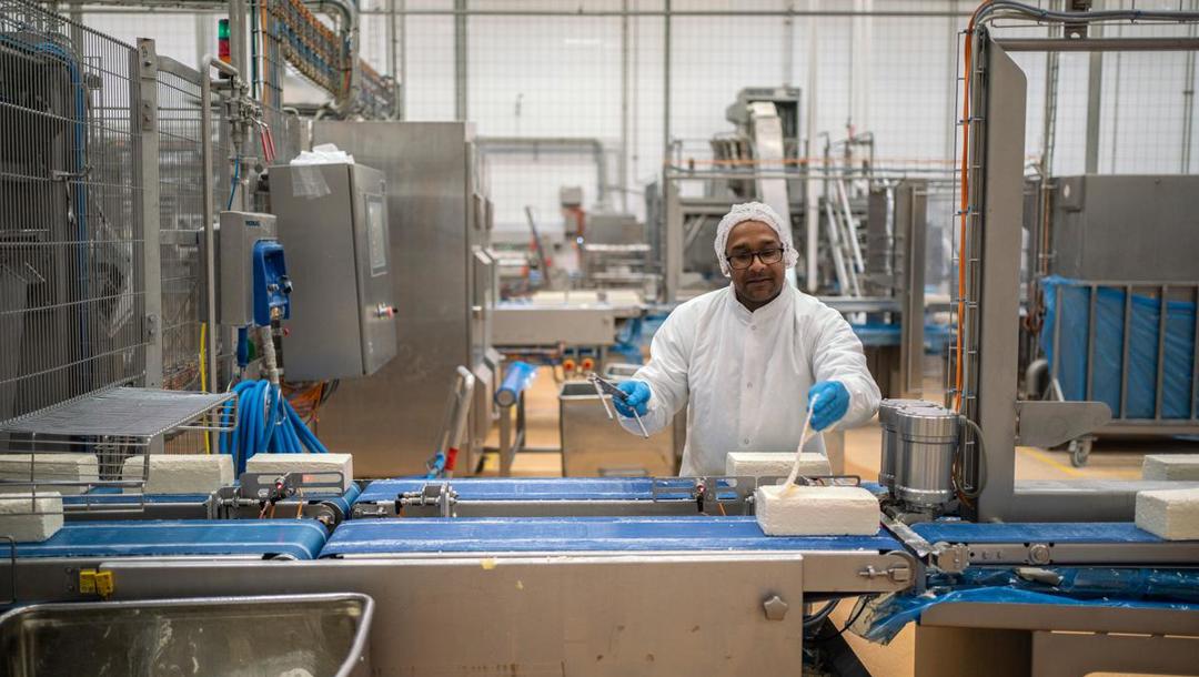 Når osten er drænet køres den over i pakkeriet, hvor Malu Bumpursun overvåger maskinerne 